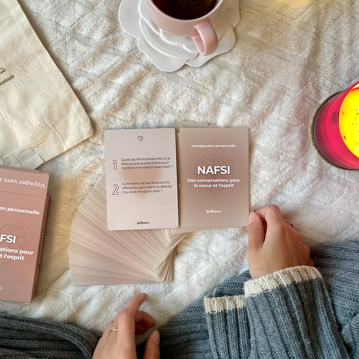 Les cartes Nafsi étalées sur un plaid, à côté d'une tasse de thé