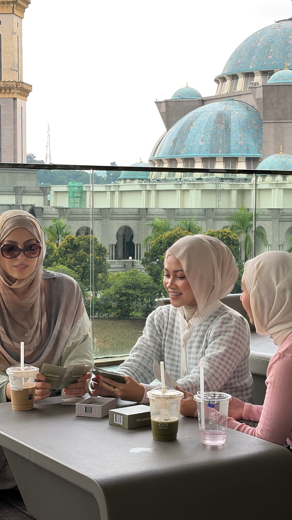 Des amies discutent autour d'une table, une mosquée au loin